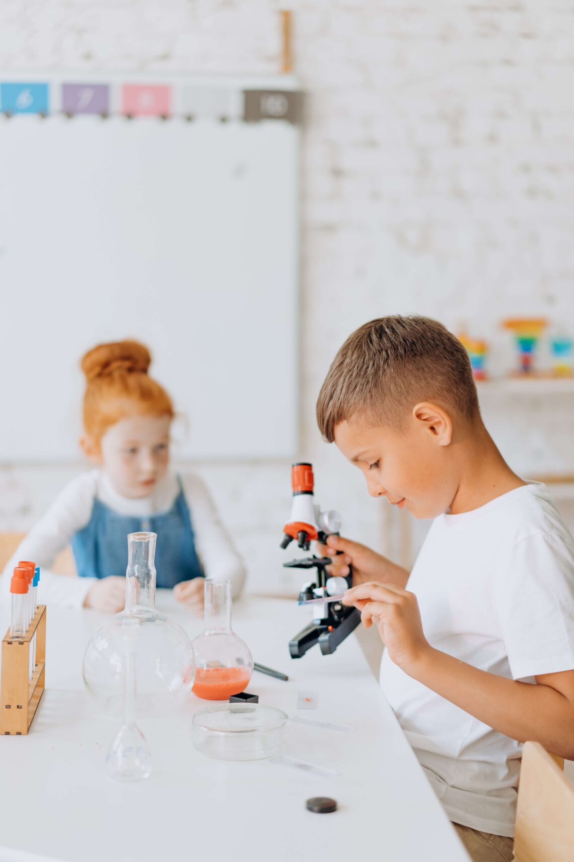 two children playing with science equipment